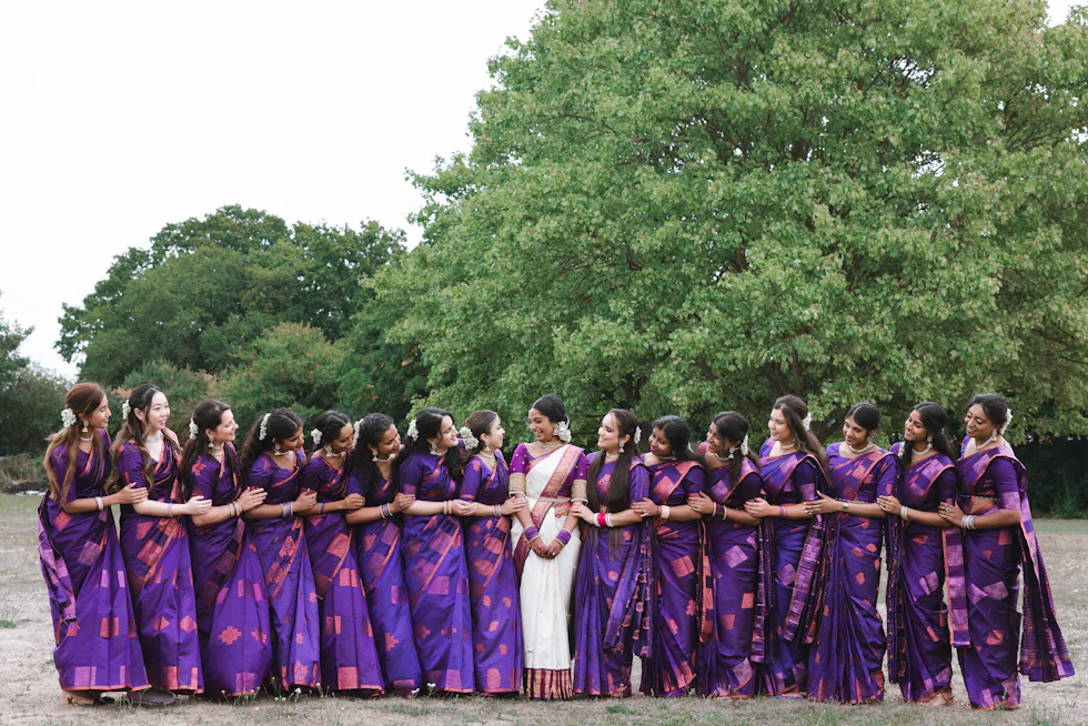 Guests in bright sarees gathered in a circle at an outdoor celebration