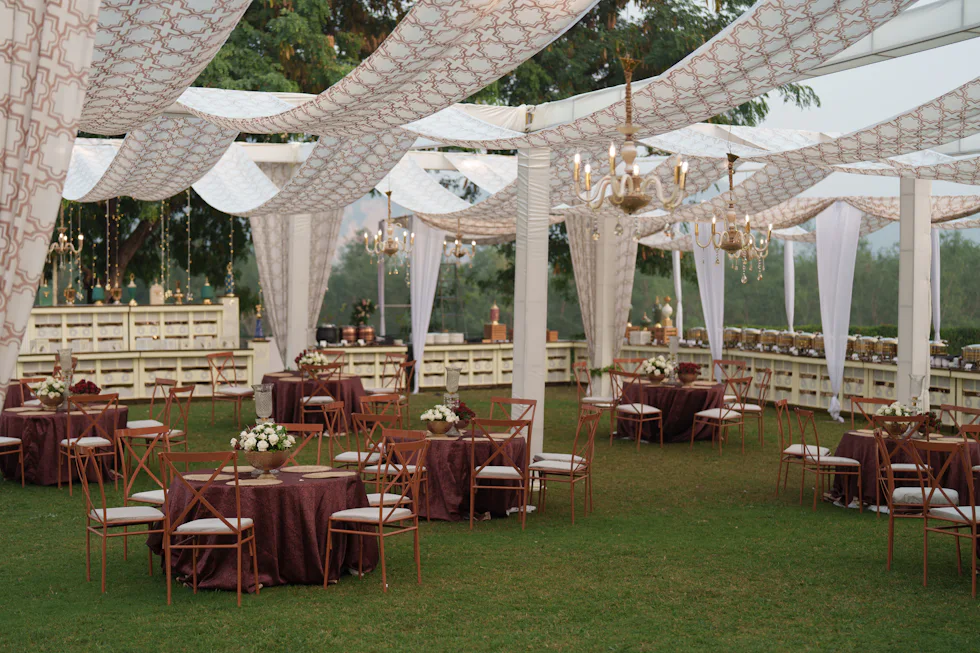 Outdoor function laid out on the lawn under draped canopies
