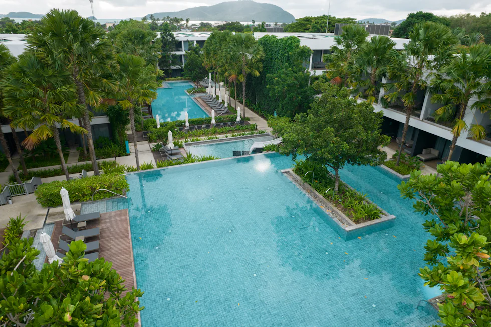 Aerial view of a resort with pools and lush green surroundings
